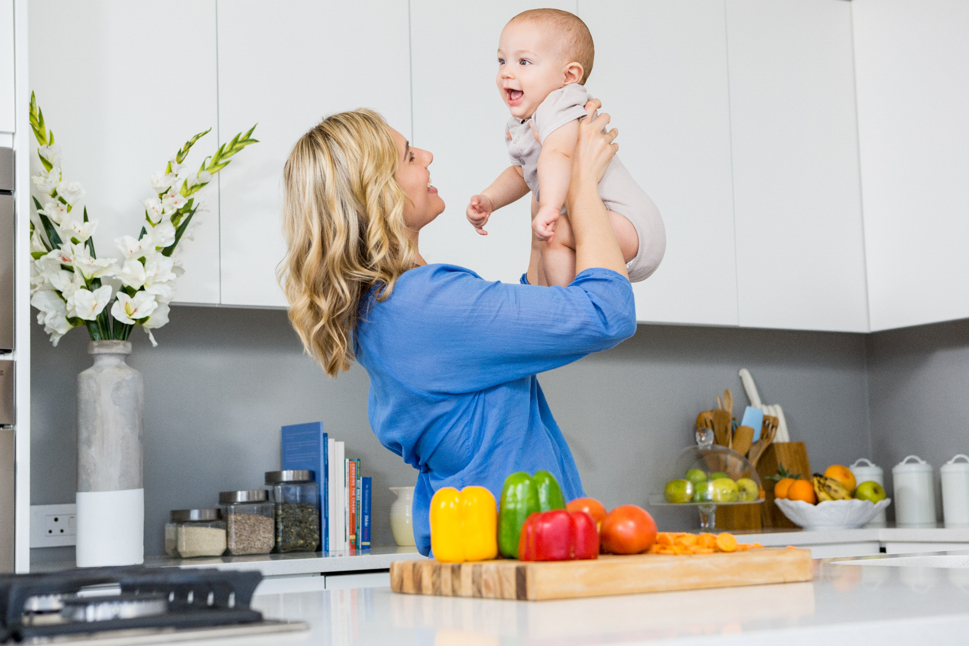 Glückliche Kundin mit ihrem Baby beim Kochen
